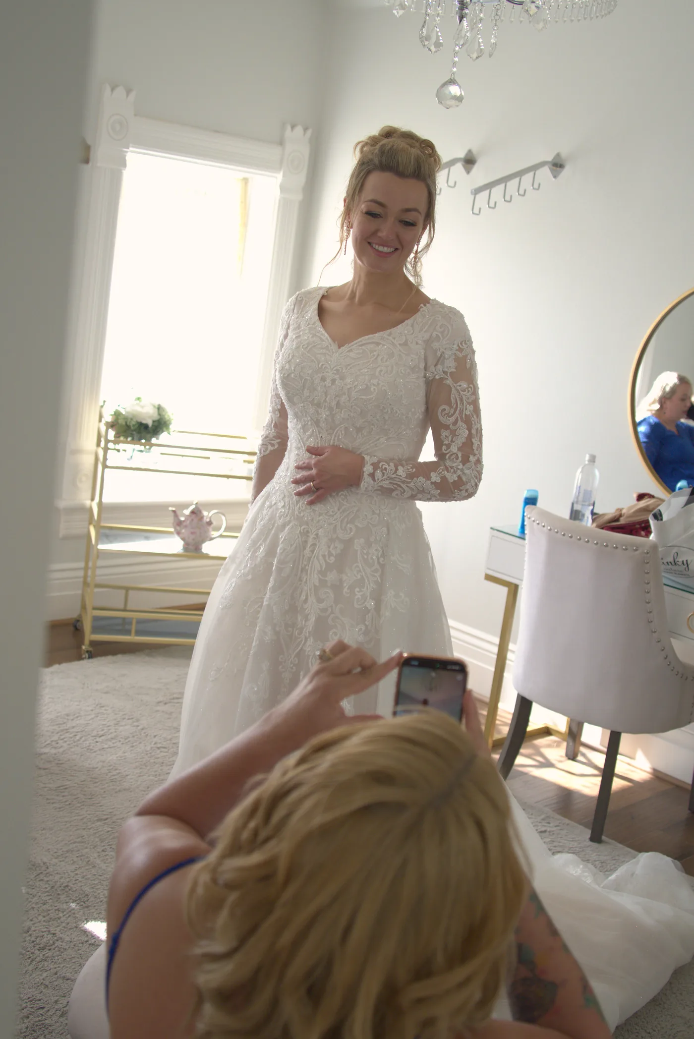 Guest filming the bride with a phone as she gets ready