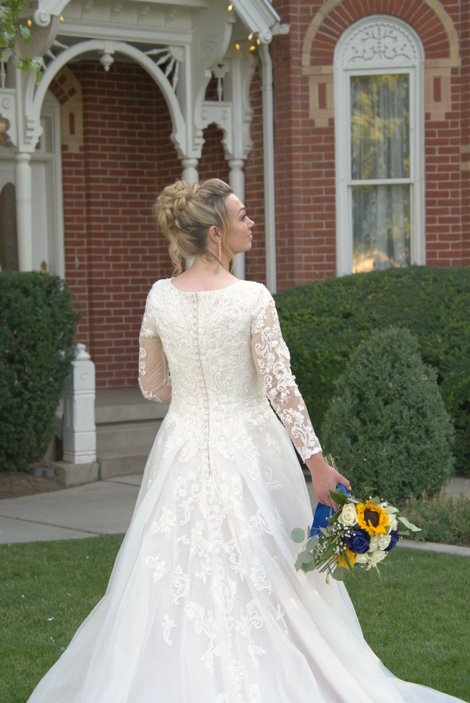Bride in her gown on the lawn of a historic home